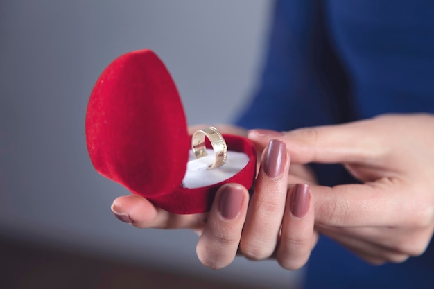 Main de femme tenant une boîte rouge avec anneau