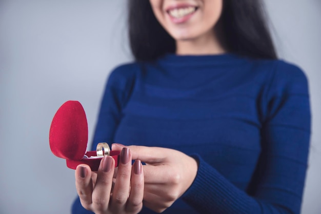 Main de femme tenant une boîte rouge avec anneau