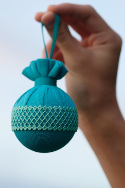 Main de femme tenant une boule de Noël