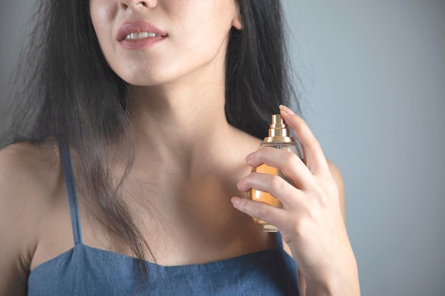 Main de femme tenant une bouteille de parfum