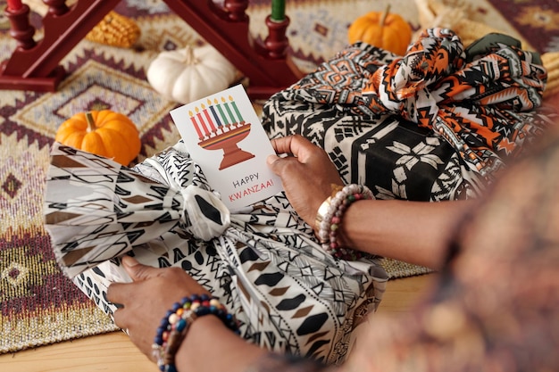 La main d'une femme tenant une carte postale kwanzaa