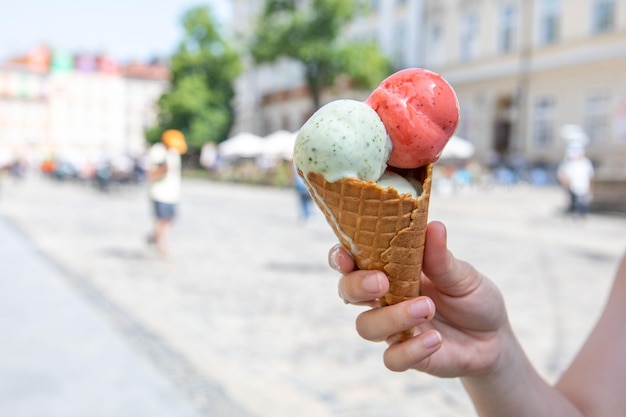 Main de femme tenant de la crème glacée fondante