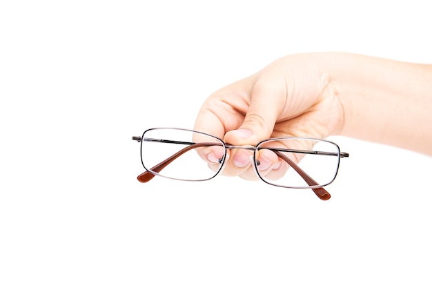 Main de femme tenant glasse sur fond blanc. Lunettes à la main