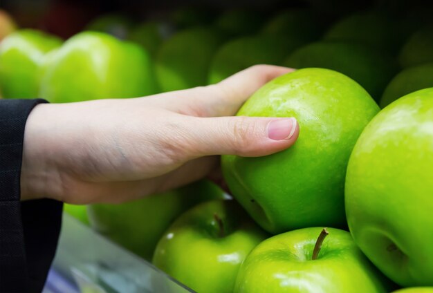 Main de femme tenant une pomme verte