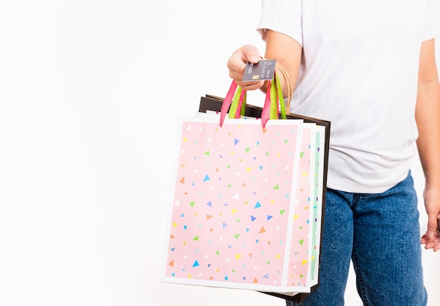 Main de femme tenant un sac à provisions coloré de nombreux paquets et carte de crédit