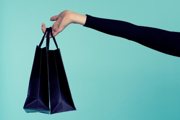 Main de femme tenant des sacs à provisions