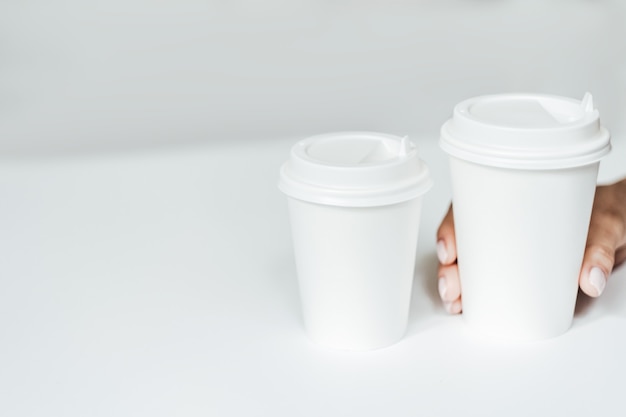 Photo main de femme tenant une tasse de papier de café