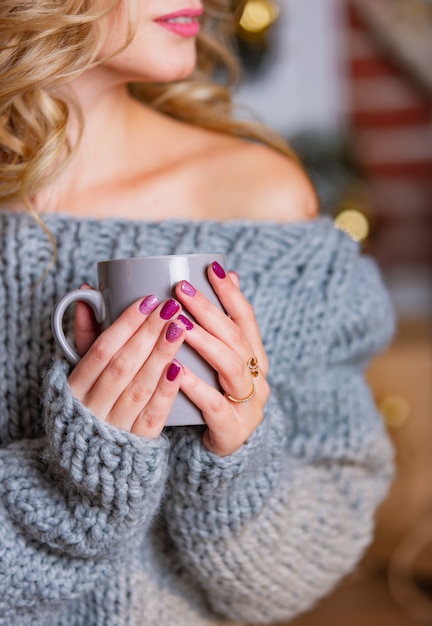 Main de femme tenant une tasse de thé