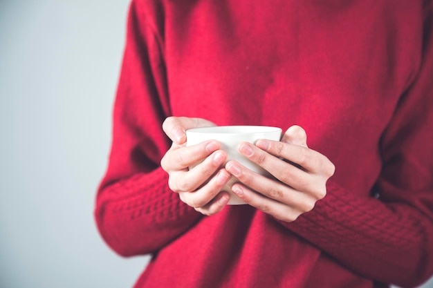 Main de femme tenant une tasse de thé