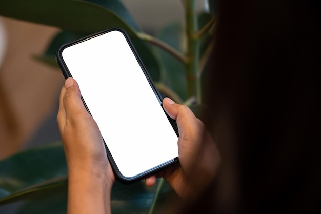 Main de femme tenant un téléphone avec un blanc