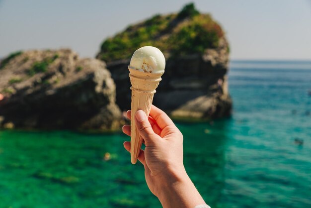 Main de femme tenir mer de crème glacée sur fond