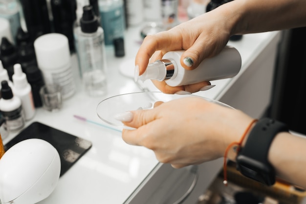 La main d'une femme tient une palette et y presse un produit cosmétique. fermer