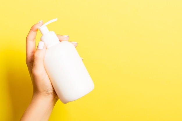 La main de la femme tient un spray cosmétique