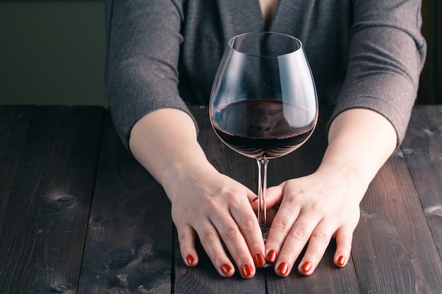 Main de femme tient le verre à vin