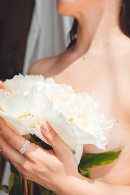 Main de femme touchant le bouquet de pivoines. espace de copie