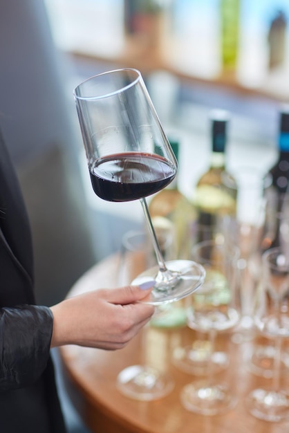 Main de femme avec un verre de vin rouge