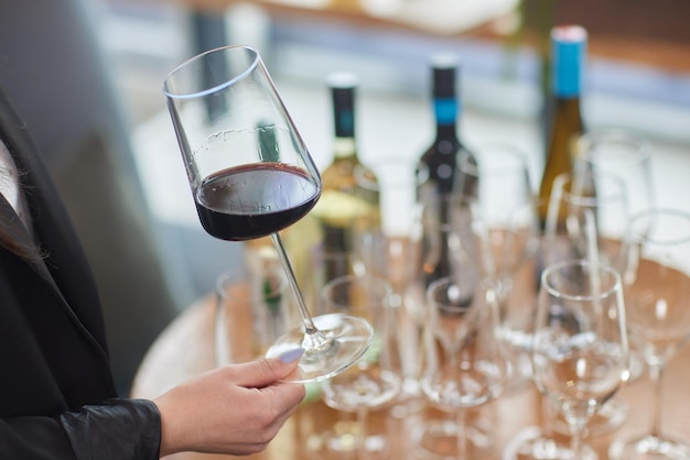 Main de femme avec un verre de vin rouge