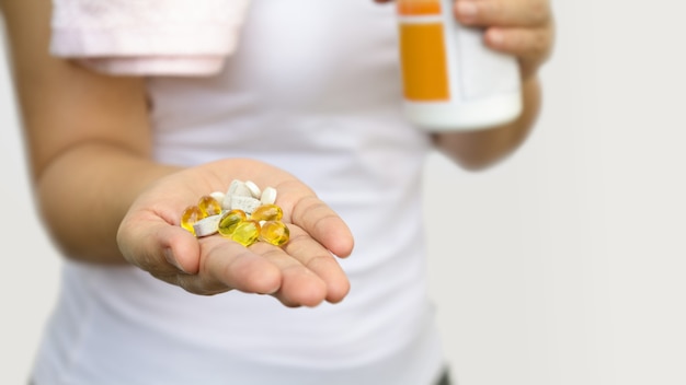 Main de femme avec des vitamines et des médicaments