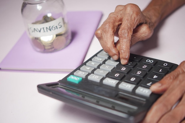 Main de femmes âgées à l'aide de la calculatrice sur le bureau