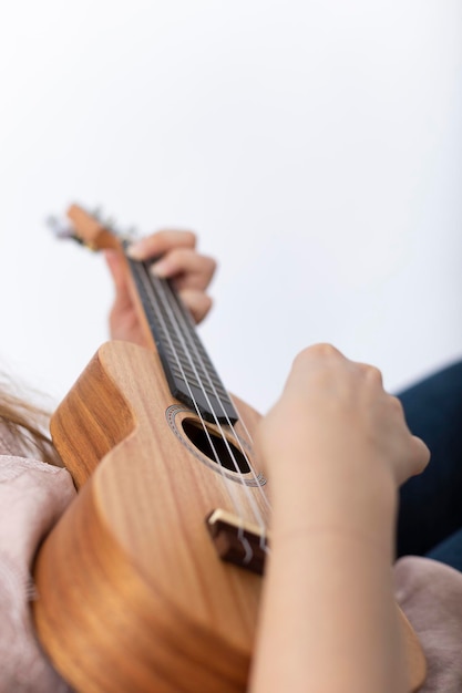 Main de fille jouant du ukulélé, petit instrument à cordes