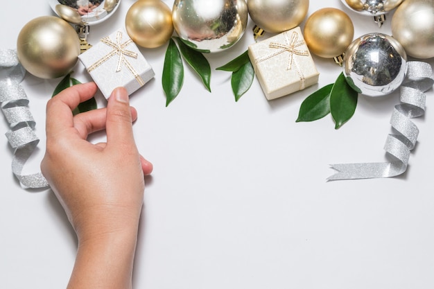 La main de la fille prend le coffret cadeau. Fête de Noël, fond avec copie