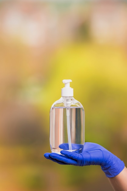 Photo main avec un gant chirurgical montre un gel désinfectant pour la prévention des coronavirus