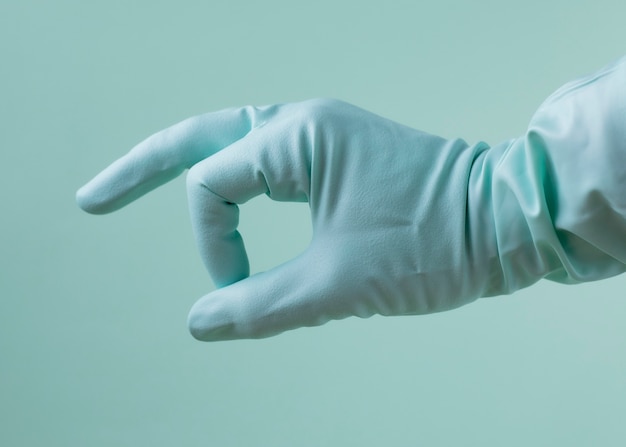 Photo main avec un gant médical sur fond vert