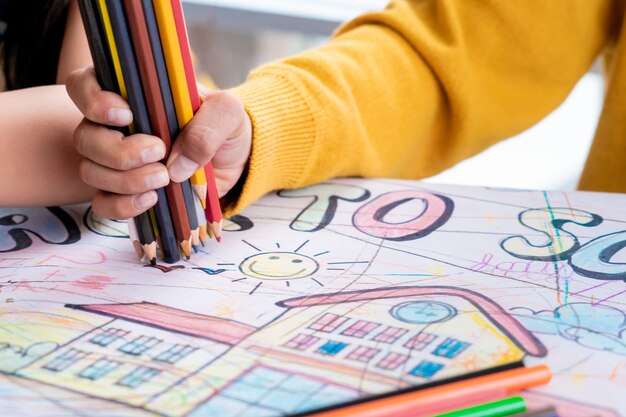 La main de garçon dessine dans la classe d&#39;art de maternelle