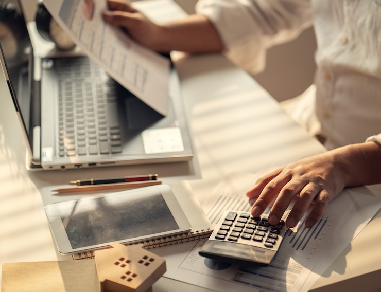 Photo main de gens d'affaires calculant les intérêts, les impôts et les bénéfices à investir dans l'immobilier et l'achat d'une maison