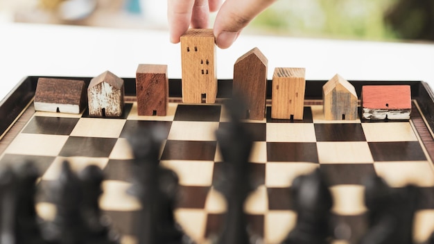 Photo la main d'un homme d'affaires déplaçant les échecs pour construire et construire des modèles dans un jeu d'échecs