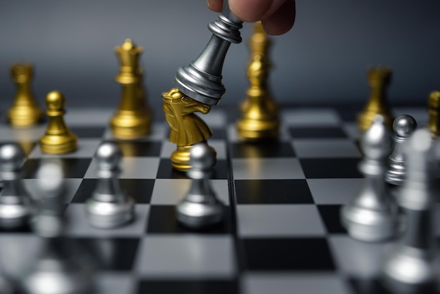 Main d'homme d'affaires déplaçant la figure d'échecs dans la réussite de la compétition jouer Concept stratégie d'entreprise rabotage et gestion ou concept de leadership