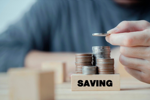 Main d'homme d'affaires mettant une pile de pièces pour économiser de l'argent investissement budgétaire ou stratégie pour le concept d'épargne personnelle économiser de l'argent pour la comptabilité financière