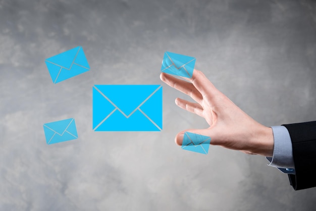 Main d'homme d'affaires tenant l'icône e-mail, contactez-nous par e-mail de newsletter et protégez vos informations personnelles contre les spams. Centre d'appels du service client contactez-nous concept