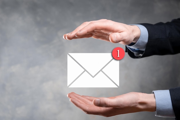 Main d'homme d'affaires tenant l'icône d'e-mail Contactez-nous par e-mail de newsletter et protégez vos informations personnelles contre les spams Centre d'appels du service client contactez-nous concept