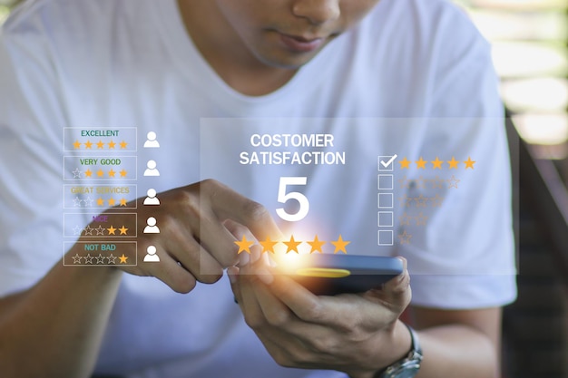 Main d'homme d'affaires tenant un smartphone avec une icône contextuelle cinq étoiles pour le service de satisfaction de l'examen des commentaires