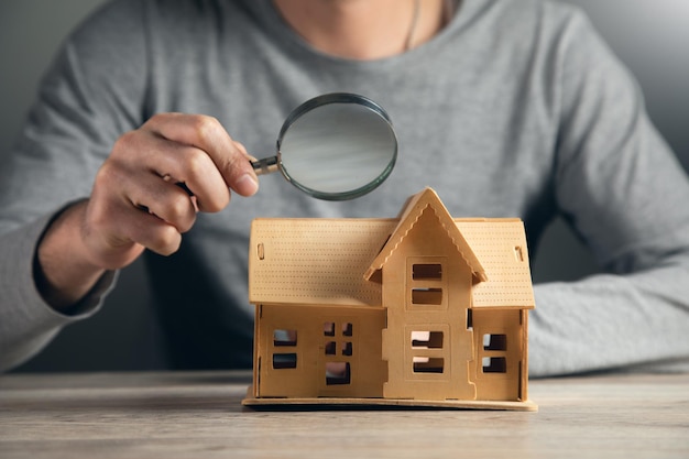 La main de l'homme d'affaires tient la loupe à la maison
