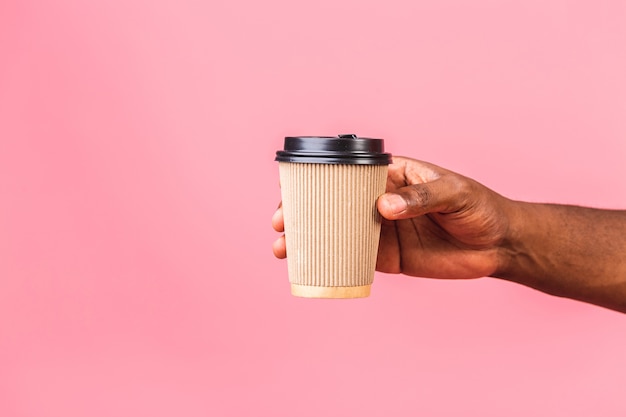 Main de l'homme afro-américain tenant la tasse de café en papier