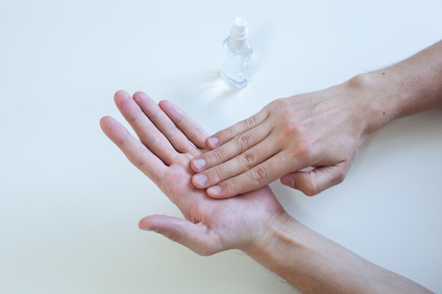 Photo main de l'homme à l'aide d'un distributeur de pompe de gel désinfectant pour les mains pour la protection du coronavirus