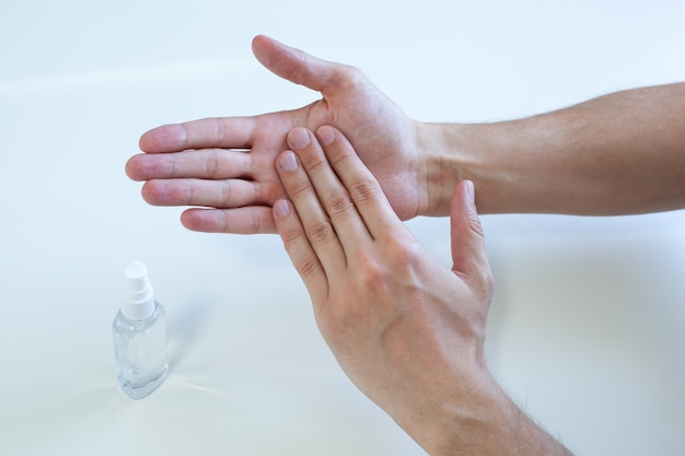 Photo main de l'homme à l'aide d'un distributeur de pompe de gel désinfectant pour les mains pour la protection du coronavirus