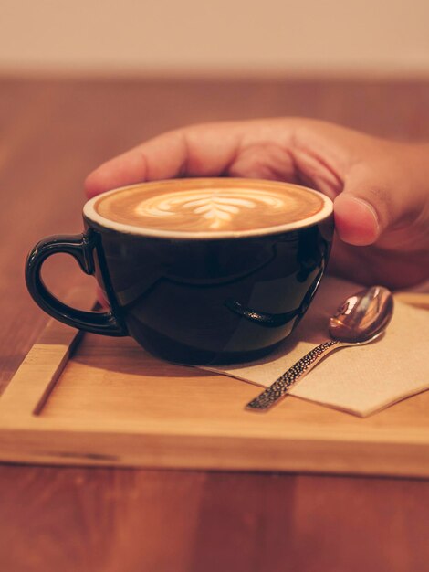 La main de l'homme buvant une tasse de café