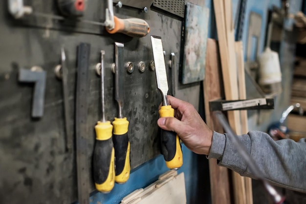 Main d'homme caucasien prenant un ciseau pour le travail du bois