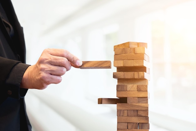 Main d'homme coupée faisant une pile de blocs de bois