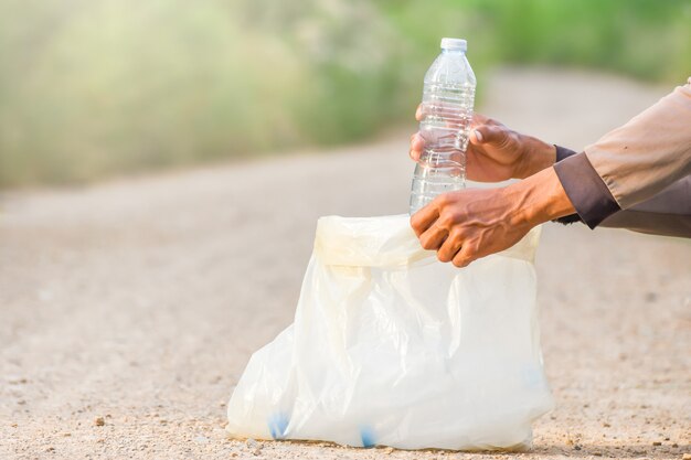 La main de l&#39;homme cueille une bouteille en plastique.