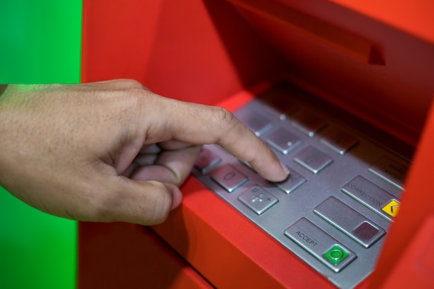 Une main d&#39;homme entrant code PIN / passe sur le clavier de l&#39;ATM / banque