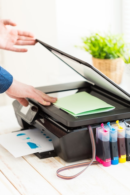 Photo main d'homme faisant des copies, travailler avec une imprimante