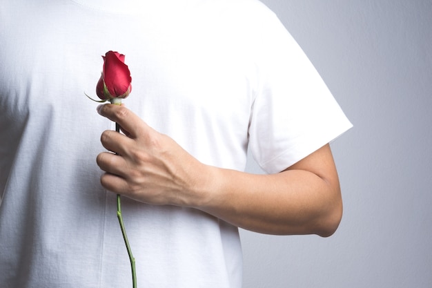 Une main d&#39;homme avec une fleur rose rouge