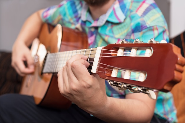 Main de l&#39;homme hipster barbu jouant de la guitare acoustique.