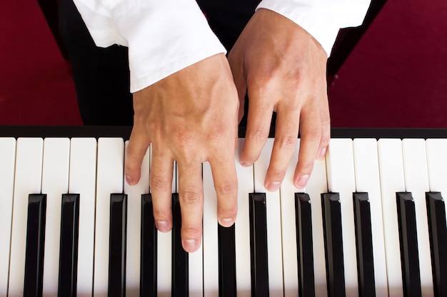 Main de l&#39;homme jouant du piano.