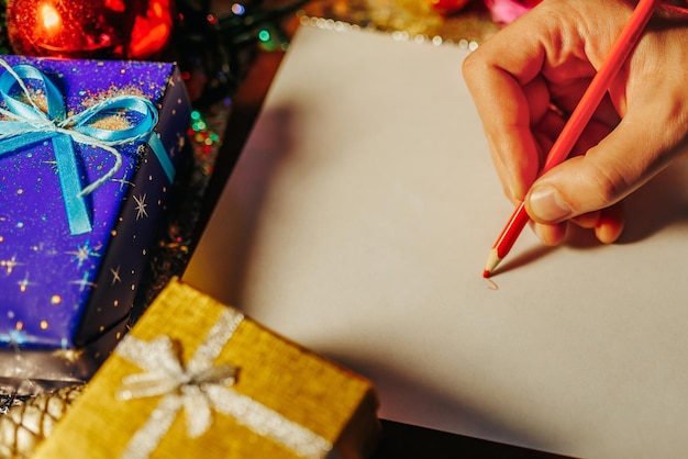 Main d'homme méconnaissable écrivant quelque chose sur une feuille de papier blanche en rouge