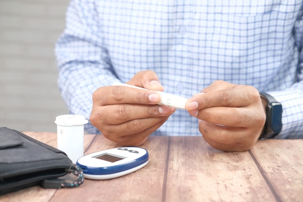 La main de l'homme mesure le niveau de sucre dans le sang